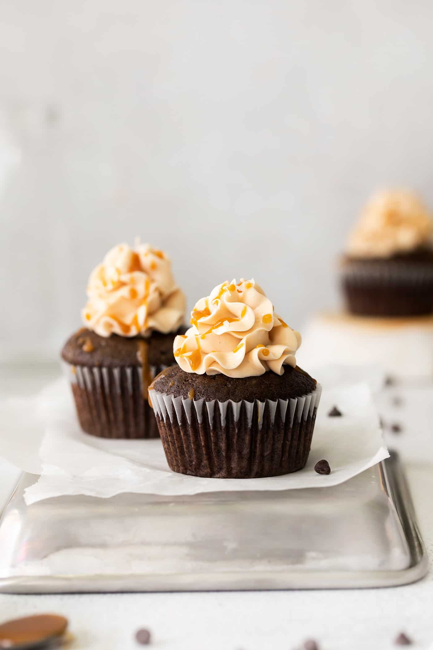 Three chocolate cupcakes frosted and topped with caramel
