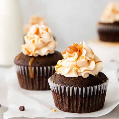 Three chocolate cupcakes frosted and topped with caramel