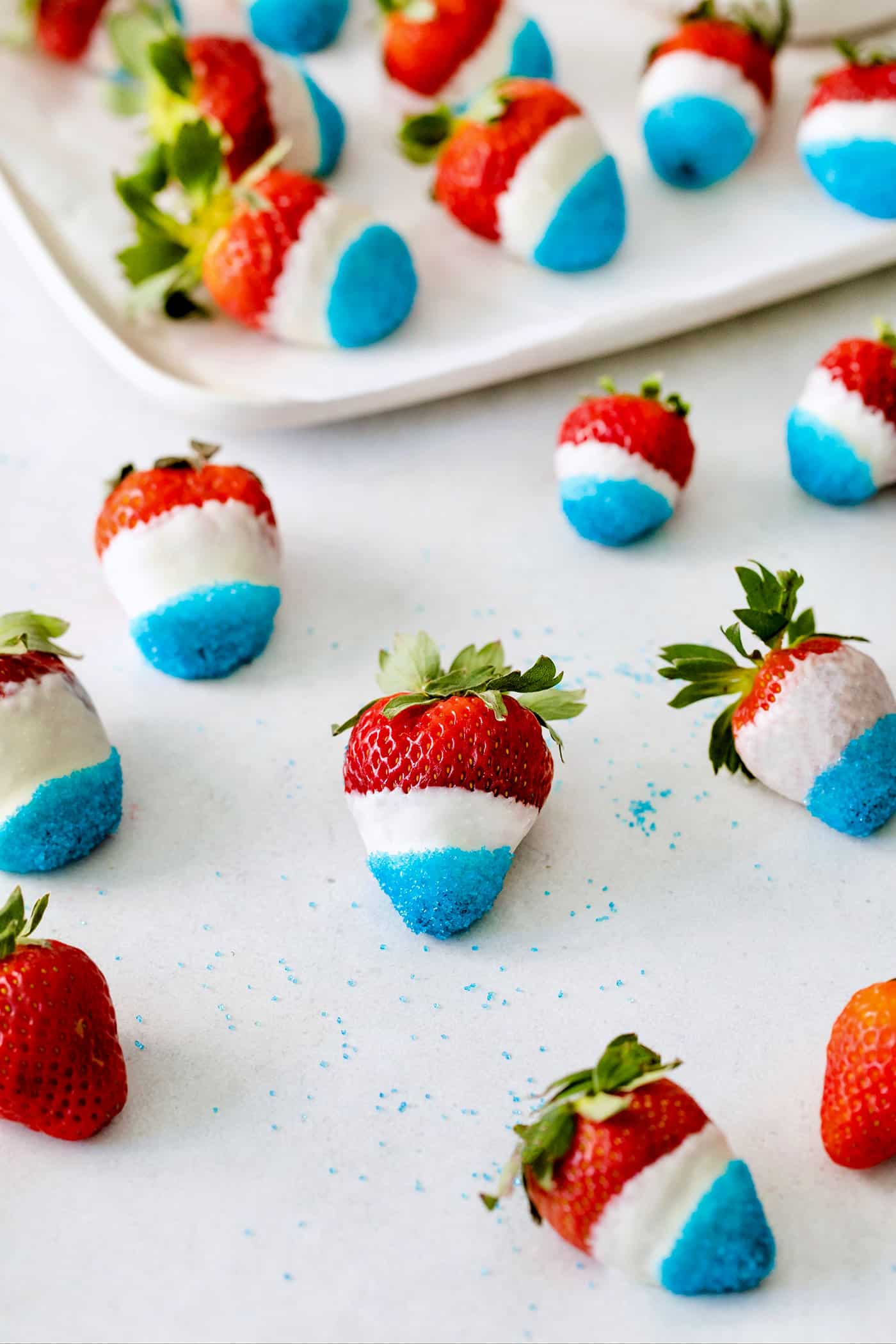 Red white and blue chocolate covered strawberries on a white surface