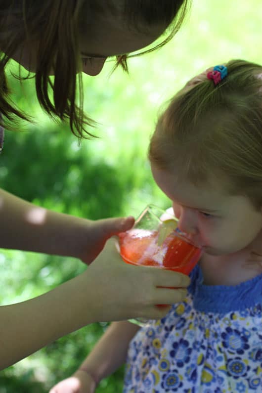 a girl drinking a glass of strawberry lemonade