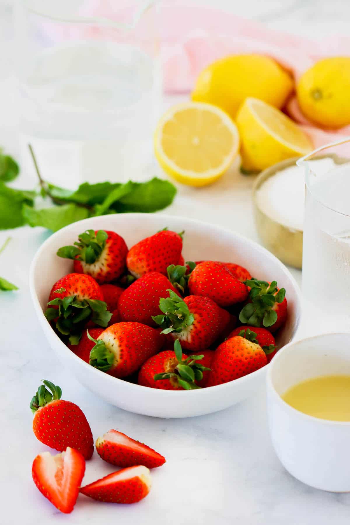 Fresh strawberries in a bowl with lemons in the background