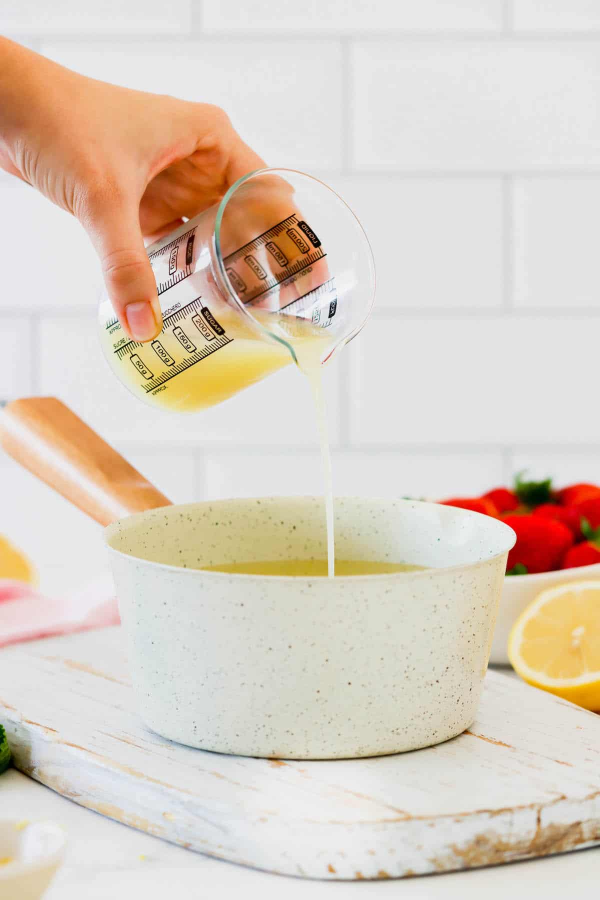 Lemon juice being poured into a pan of water