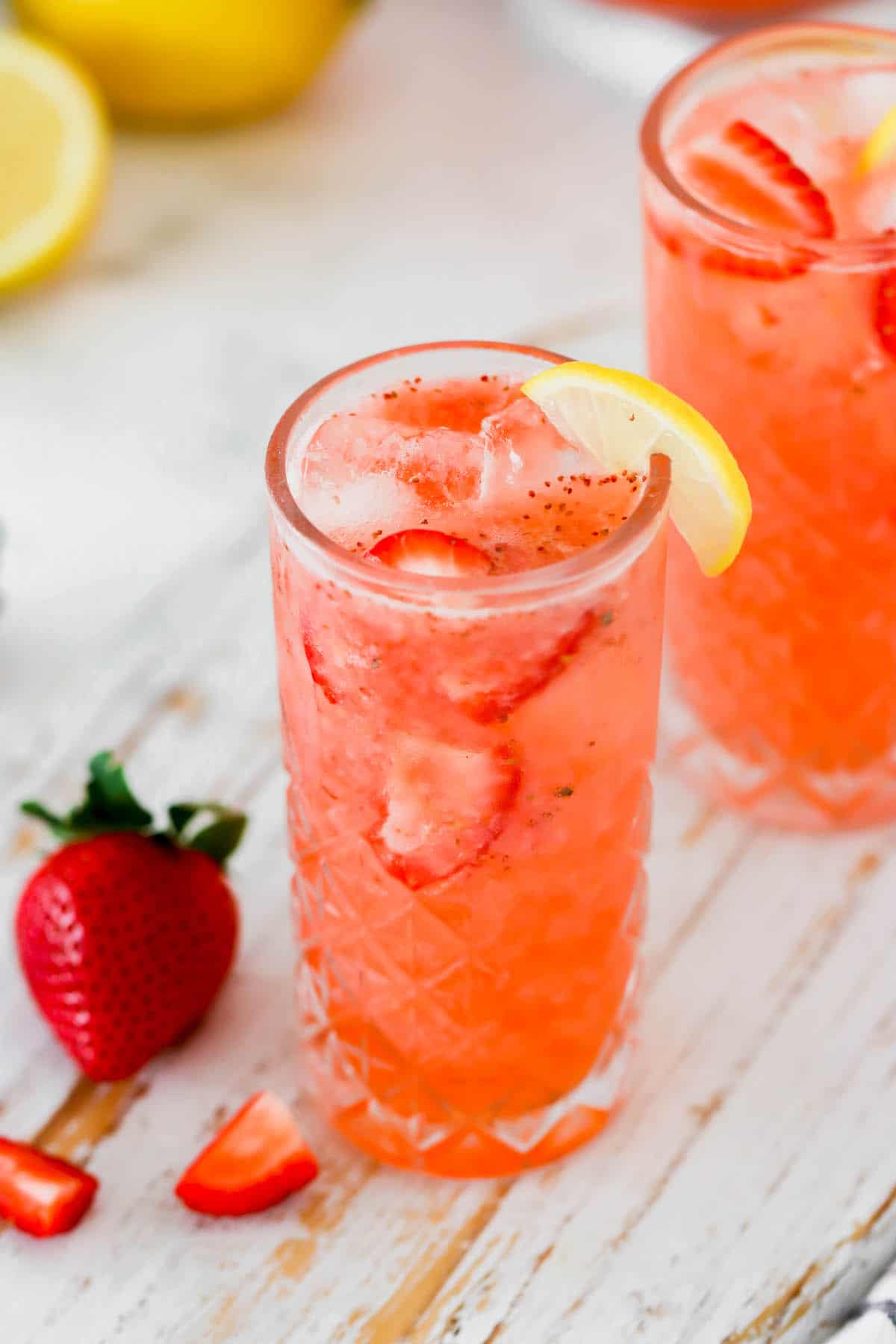 A glass of fresh strawberry lemonade with a lemon wedge