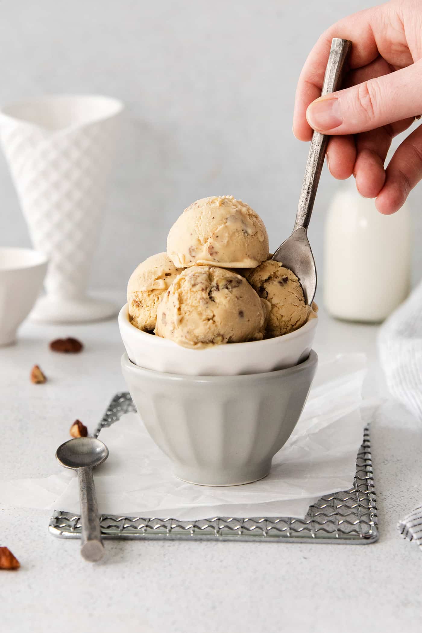 A spoon in a dish of butter pecan ice cream