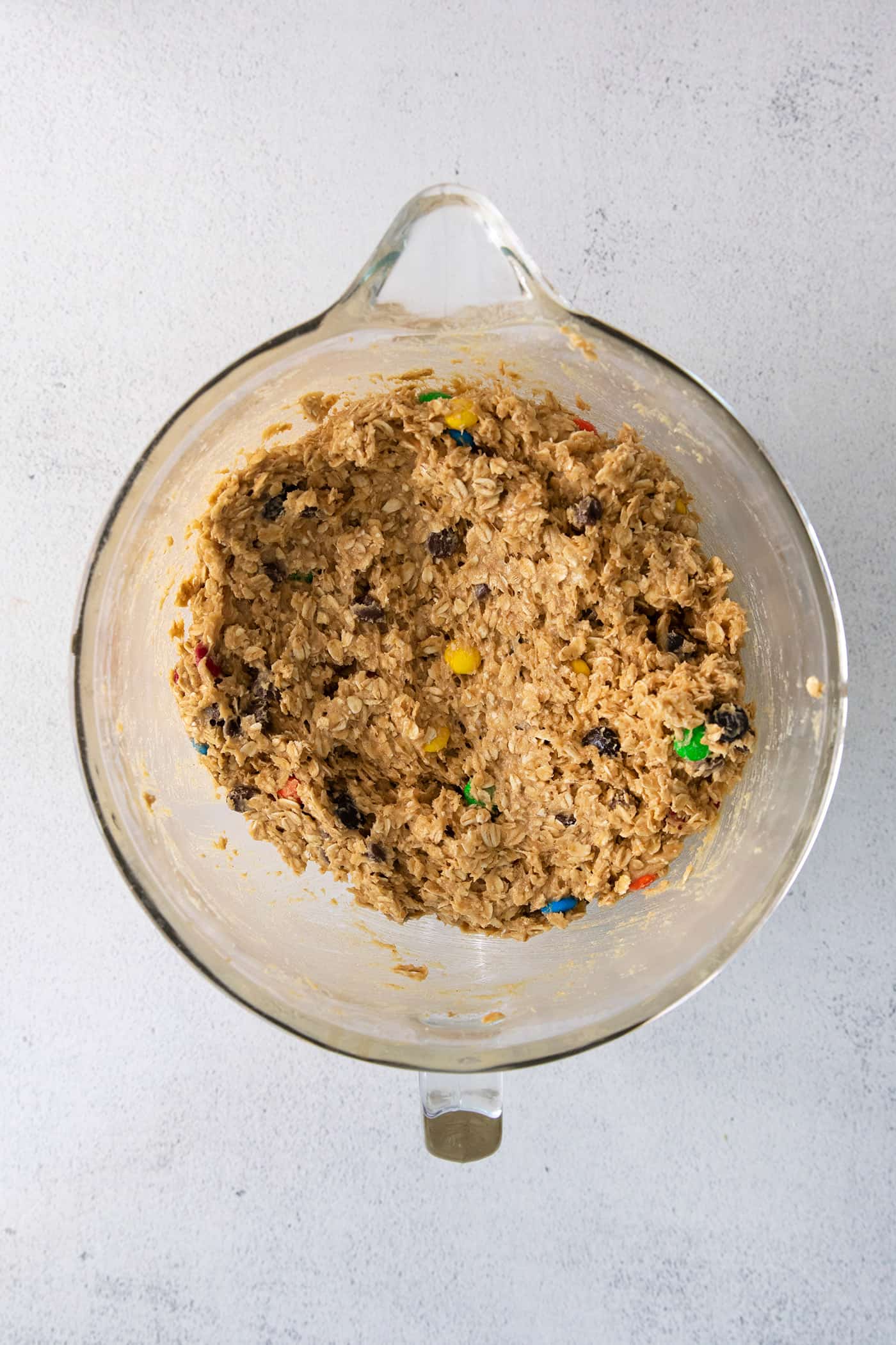 Monster cookie dough in a glass mixing bowl