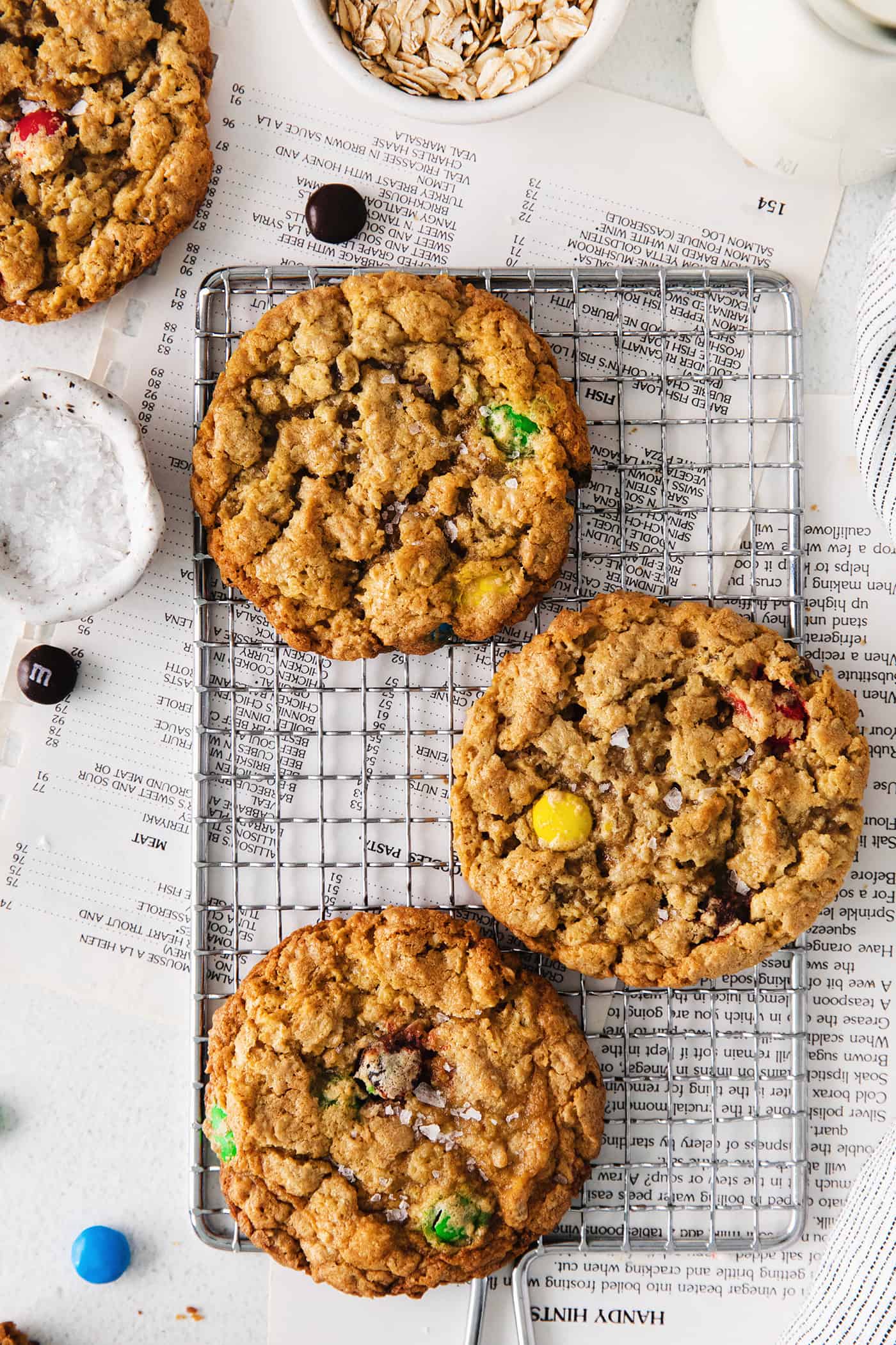 Overhead view of 3 monster cookies on a cooling rack