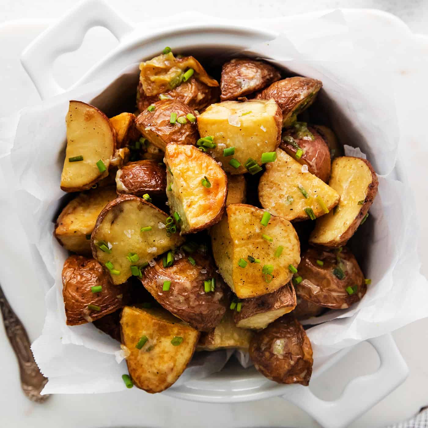 Overhead view of a bowl of garlic roasted new potatoes