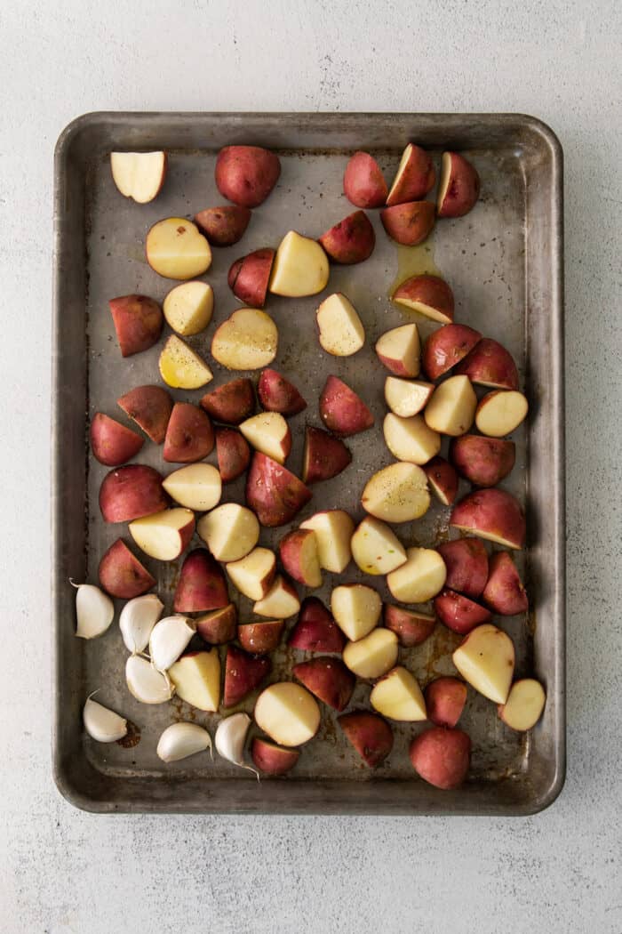 Halved red baby potatoes on a baking sheet