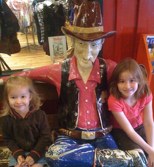 two girls with a cowboy statue