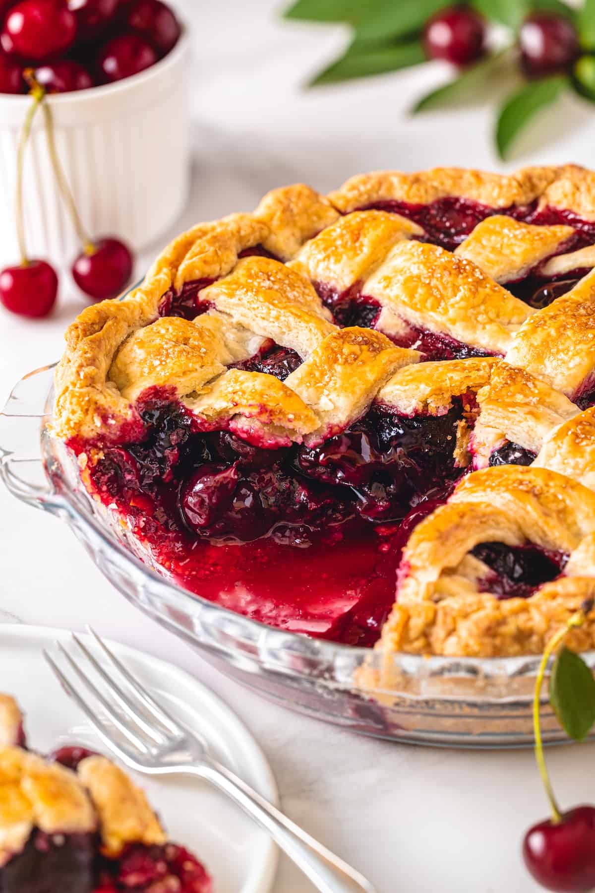 Angled view of a cherry pie with a slice missing