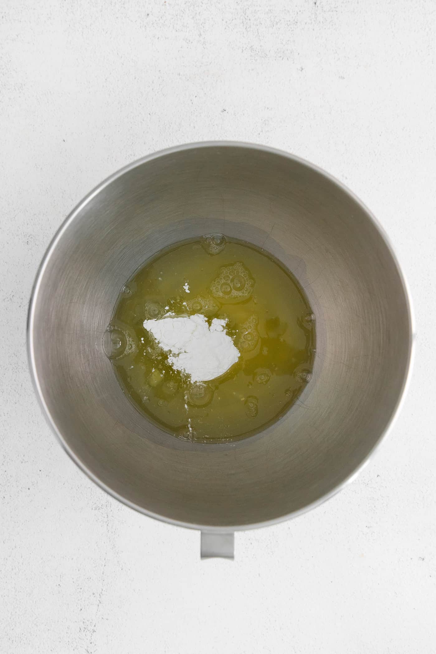 Egg whites and cream of tartar in a mixing bowl