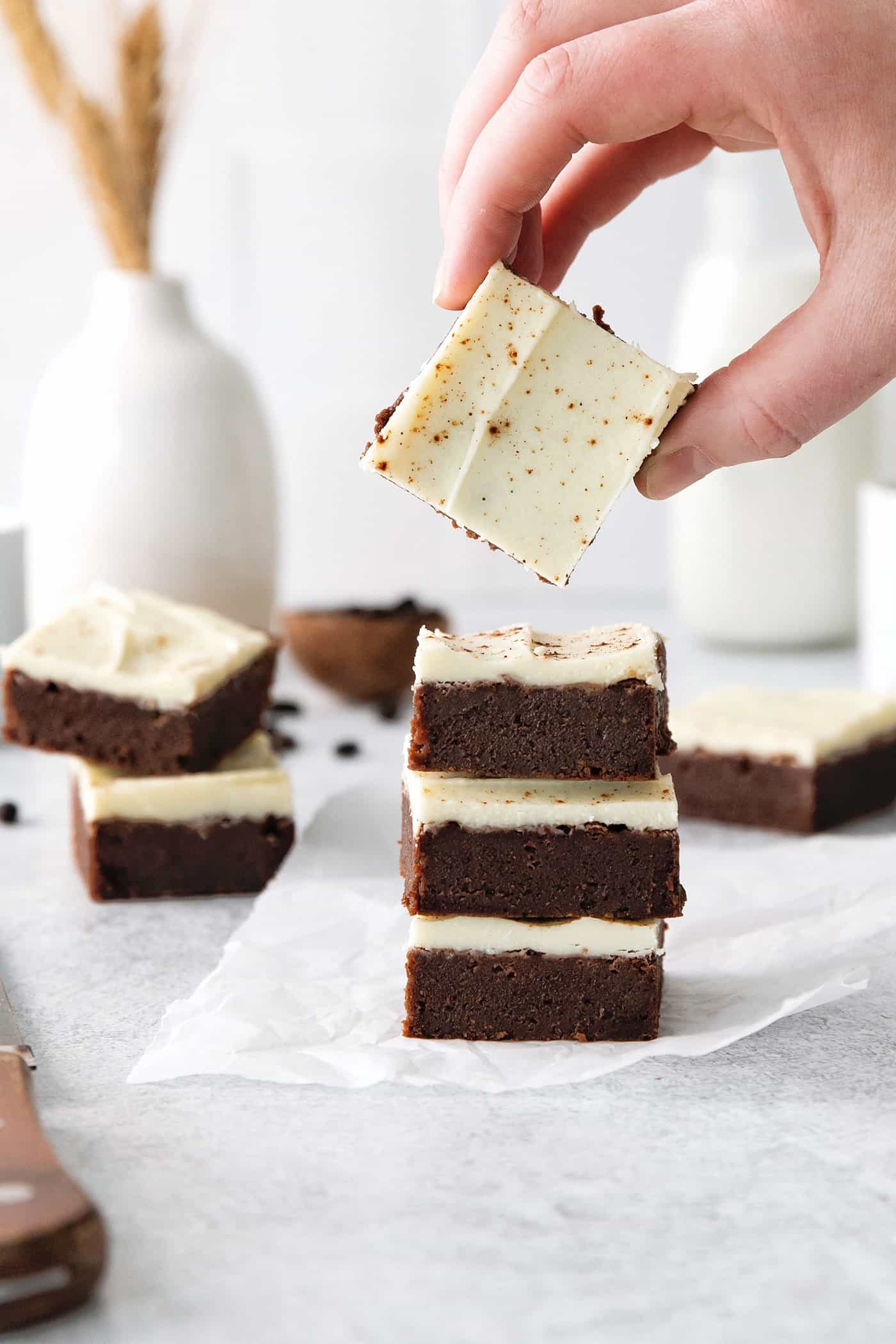 A stack of cappuccino brownies with a hand holding one