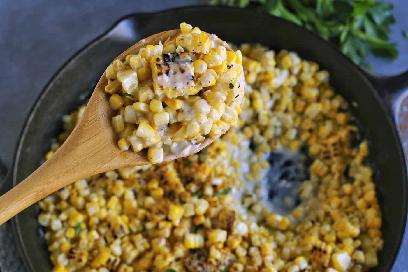 A spoon holding up spoonful of grilled creamed oven