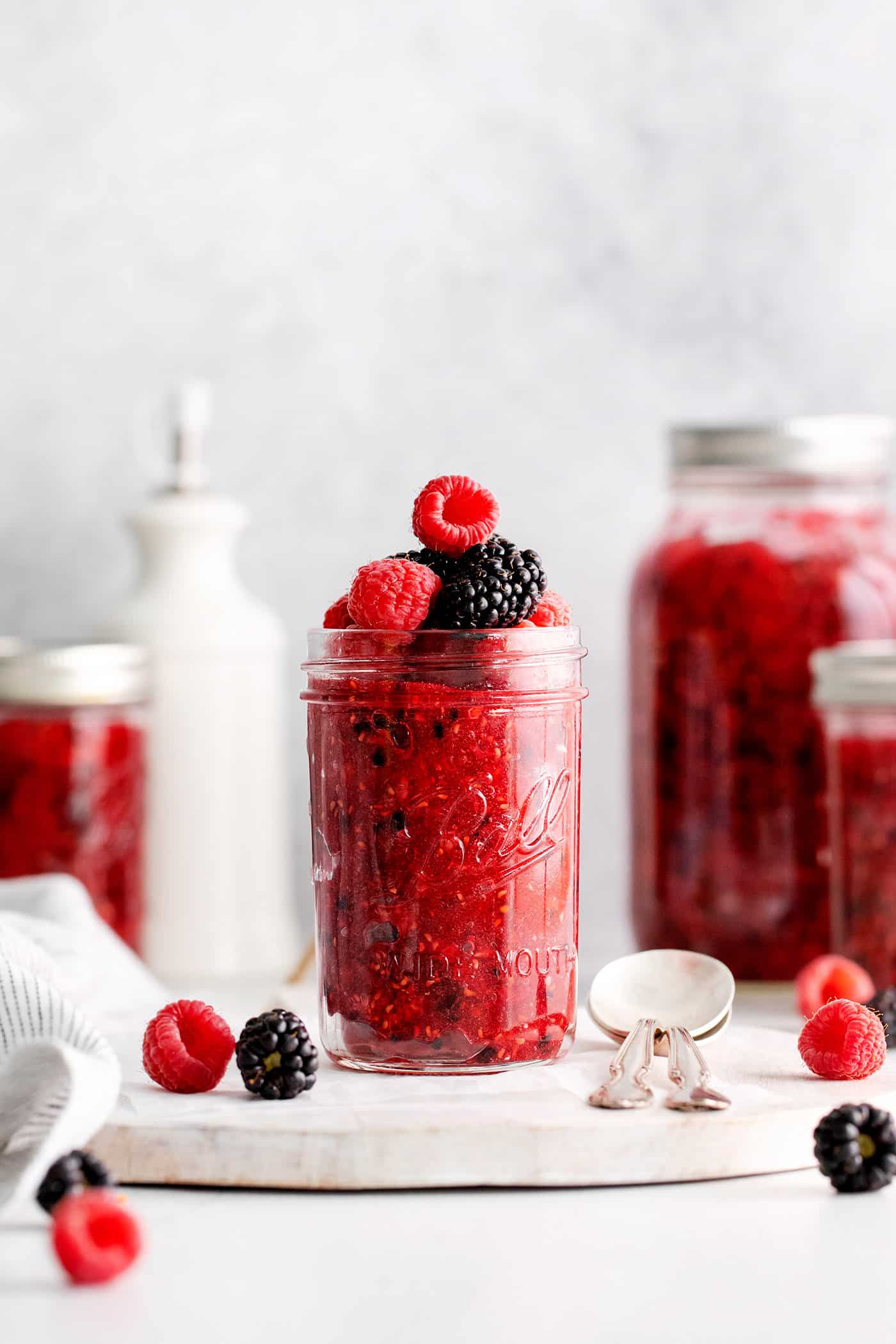 This Raspberry Blackberry Freezer Jam comes together in less than an hour, with just 4 ingredients. No cooking or canning is required! Front view of a jar of raspberry blackberry freezer jam