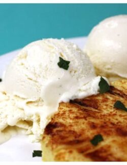 a grilled piece of pineapple with two scoops of coconut ice cream