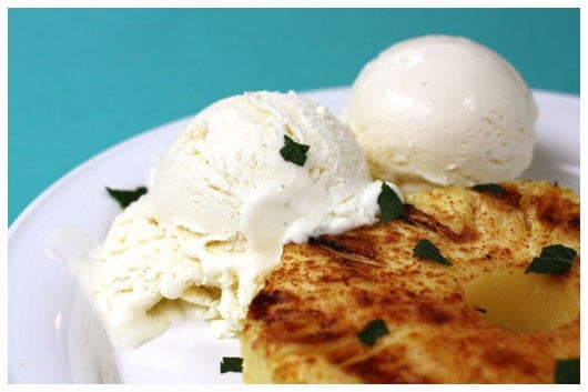 a grilled piece of pineapple with two scoops of coconut ice cream