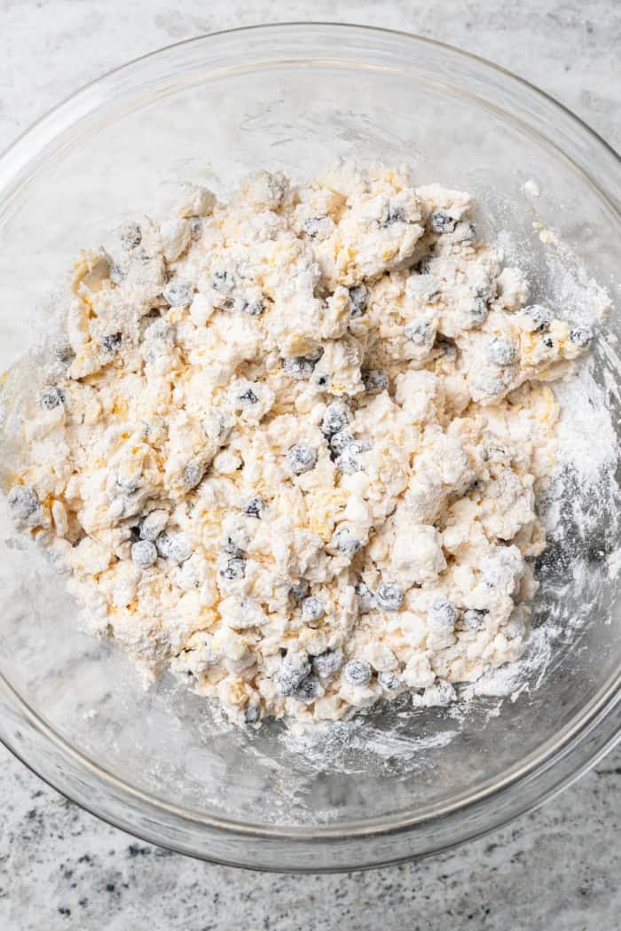 Overhead view of blueberry scone dough in glass mixing bowl