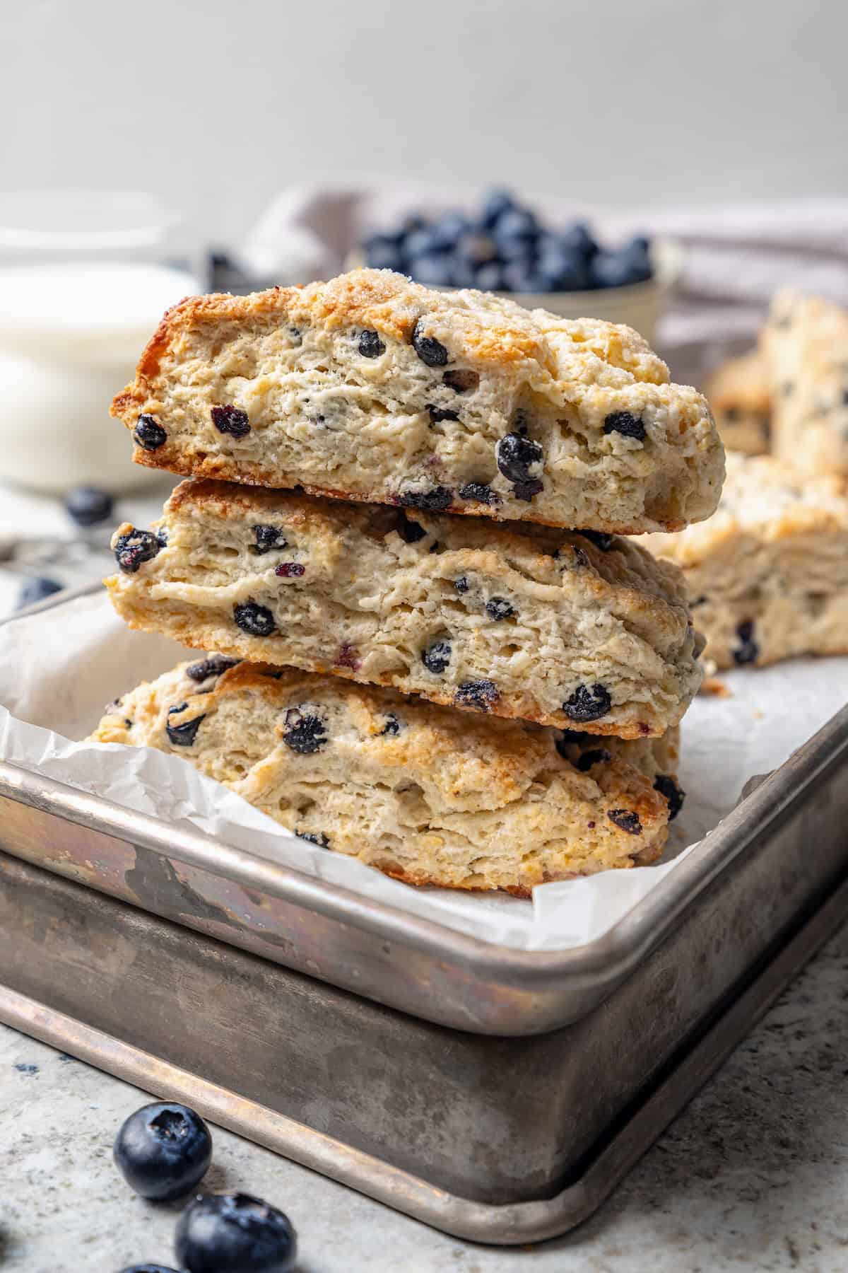 Stack of 3 homemade blueberry scones on baking sheet