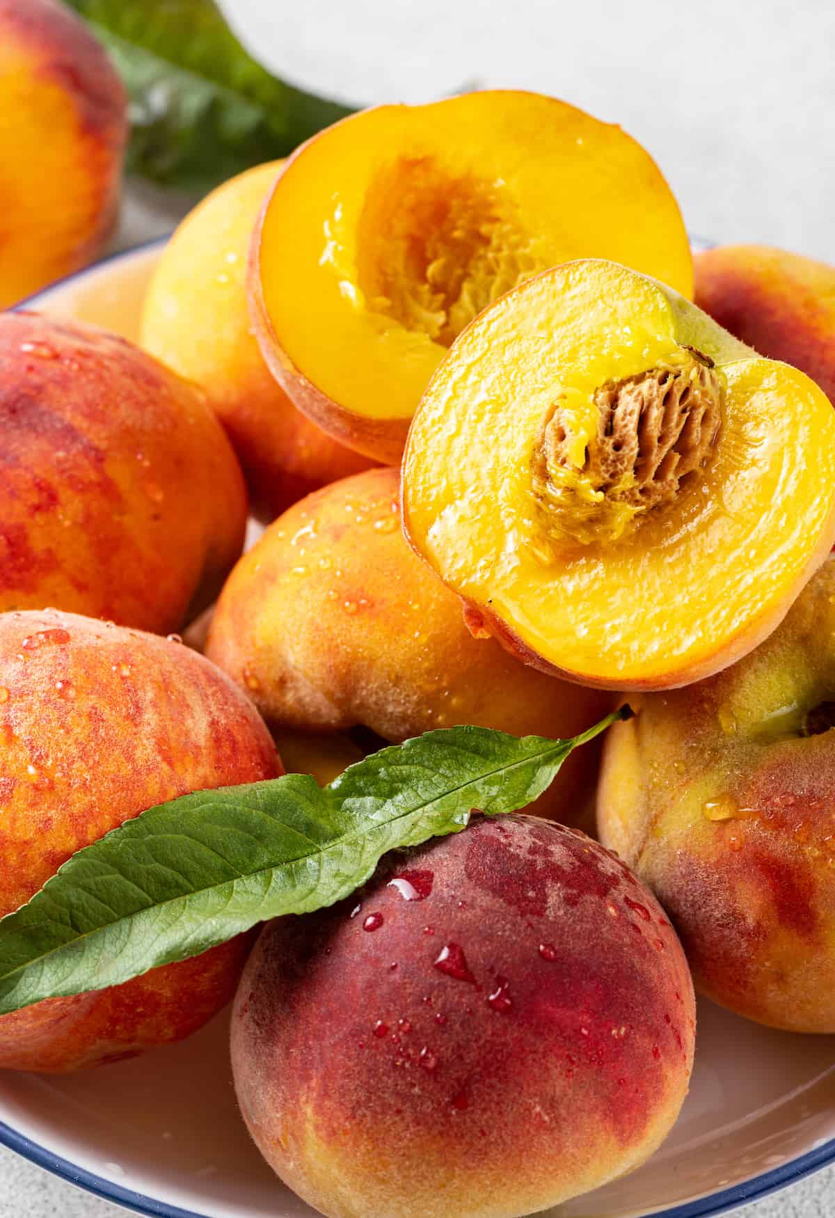 A bowl of peaches, some cut in half