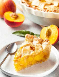 A slice of peach pie on a white plate