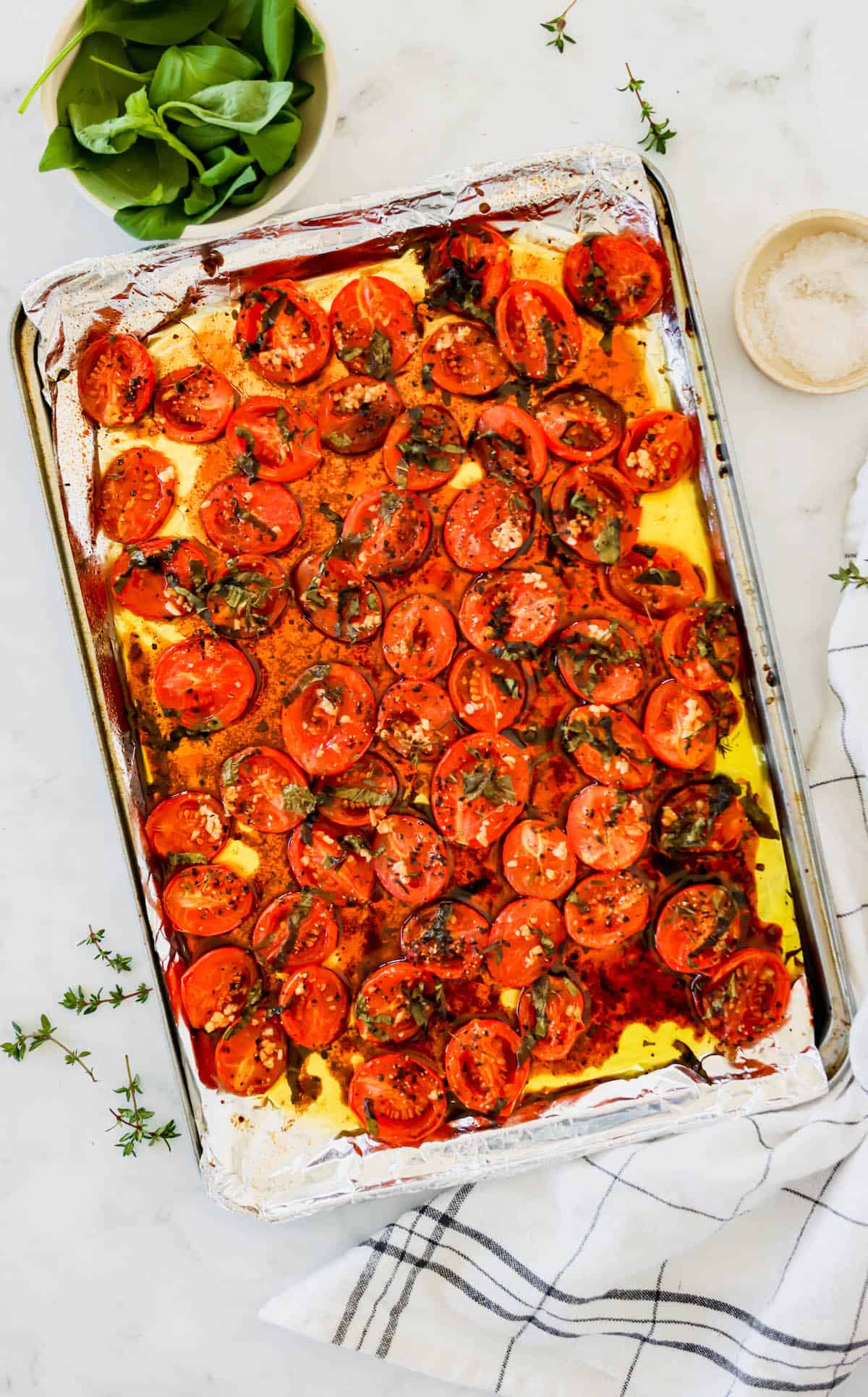 Tomatoes on a sheet pan with olive oil and seasonings