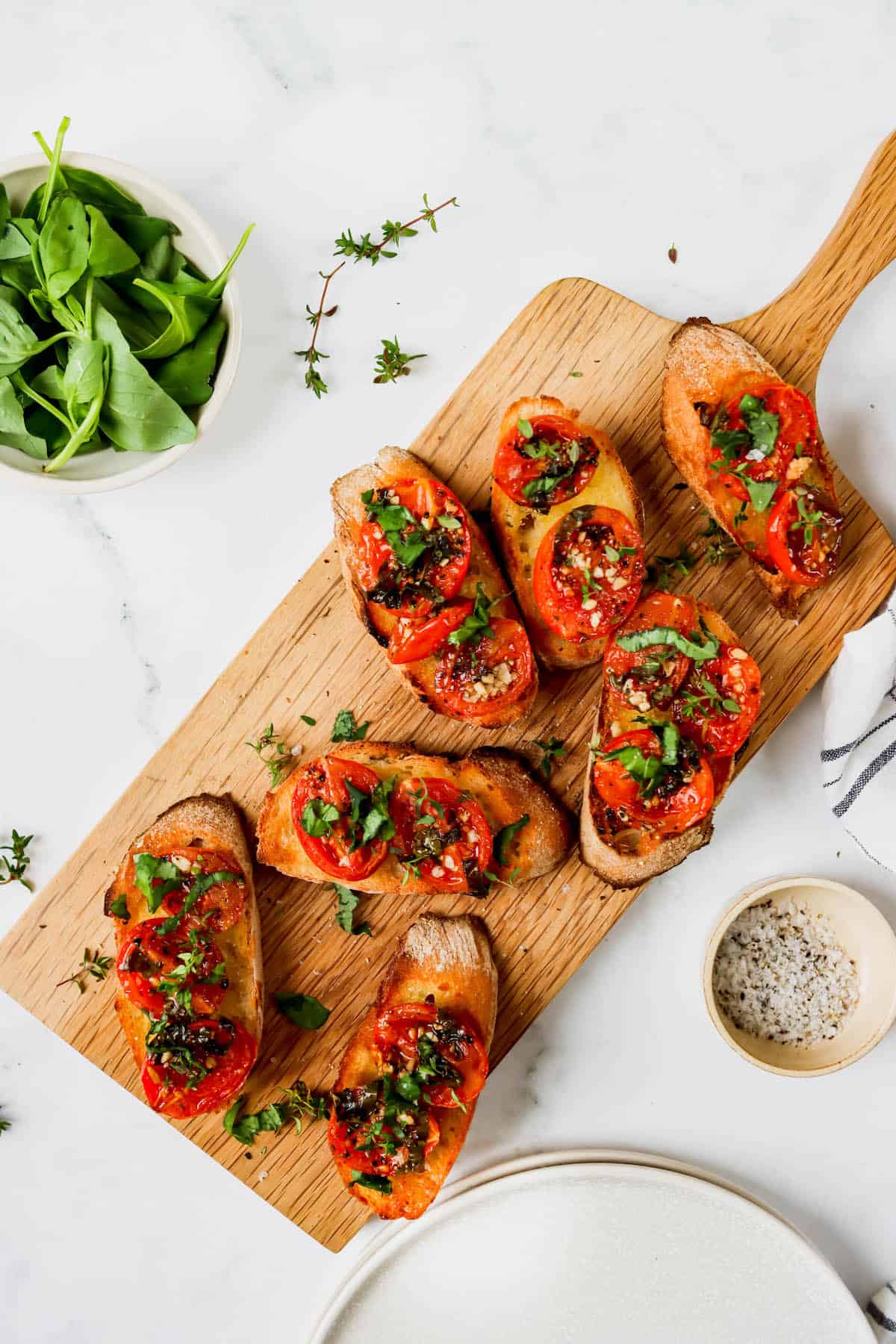 Sliced baguettes topped with roasted tomatoes