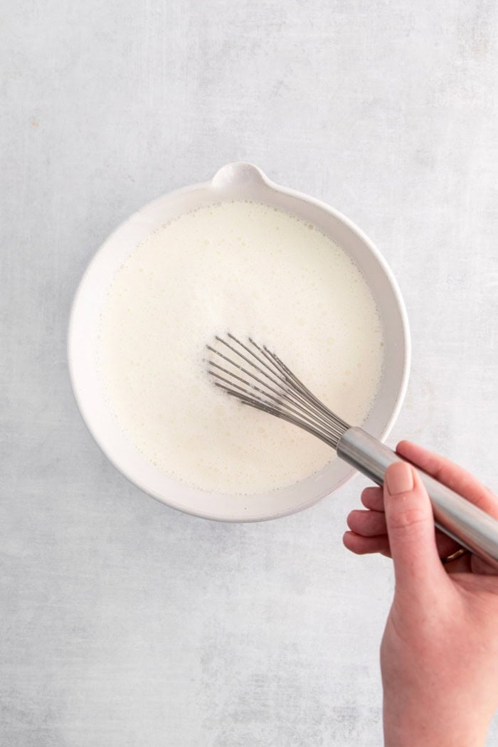 Whisking coconut ice cream ingredients in bowl