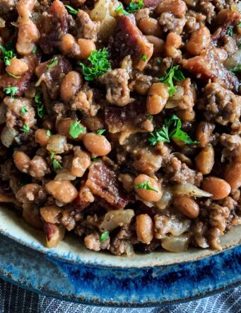 a bowl of baked beans with bacon and ground beef