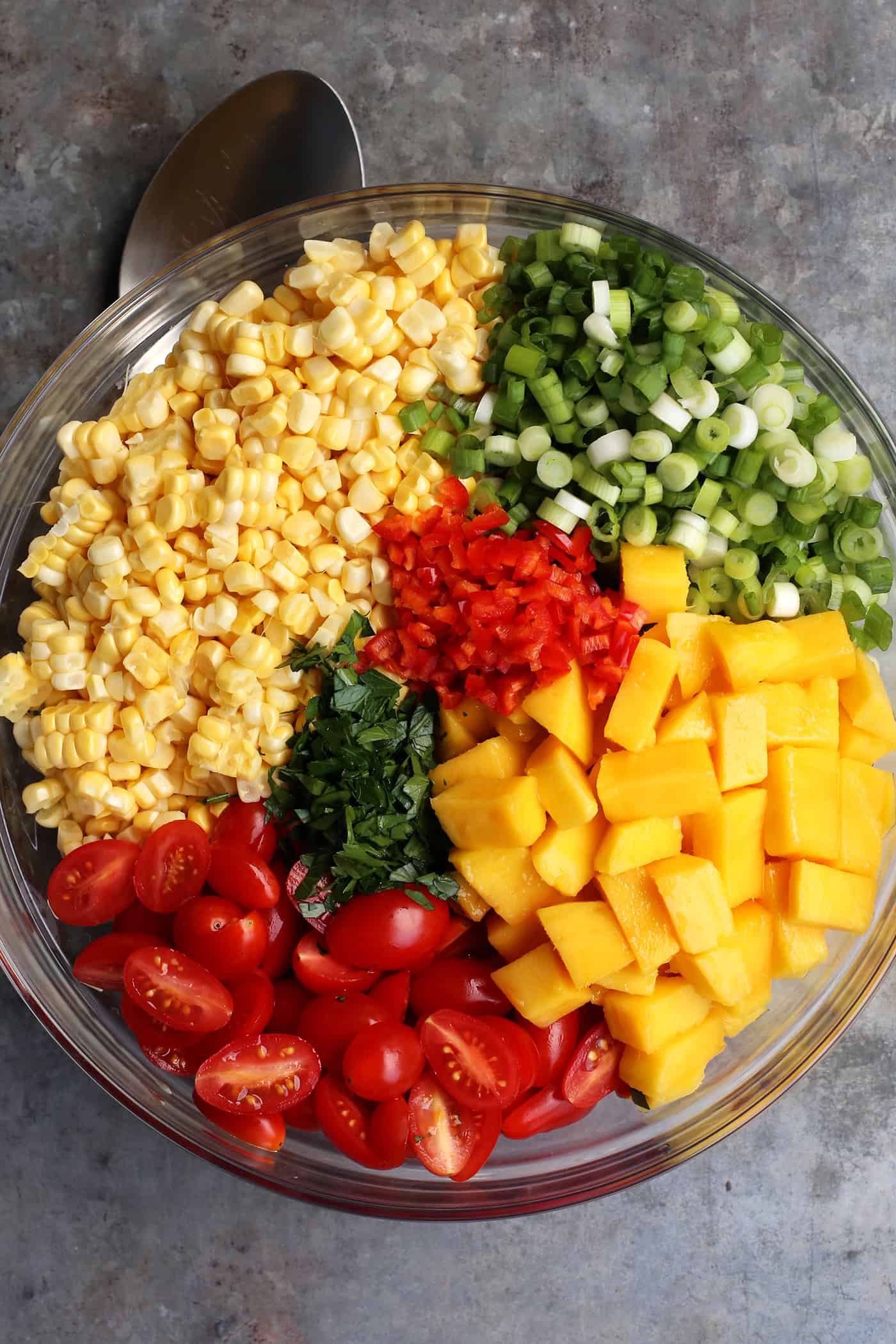 All the ingredients of sweet corn salad in a glass bowl