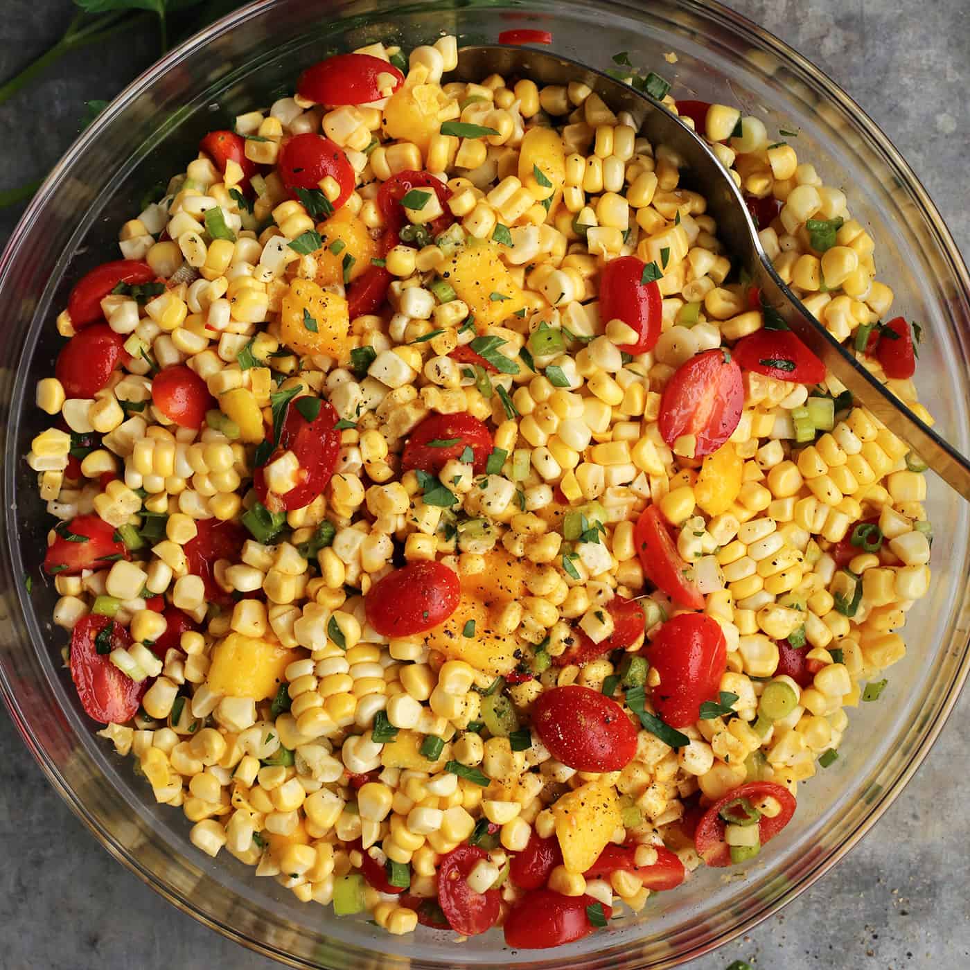 Overhead view of corn and tomato salad in a glass bowl