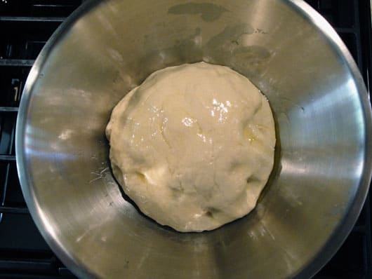 a metal bowl of pizza dough