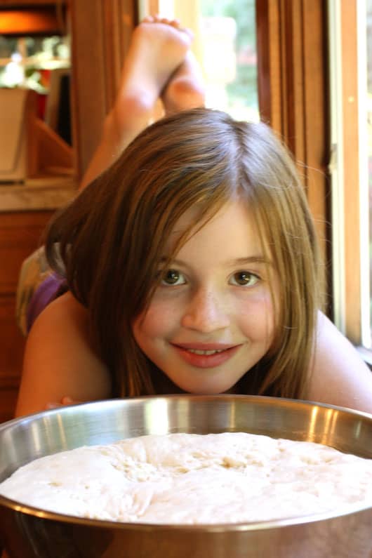 a girl with a bowl of pizza dough