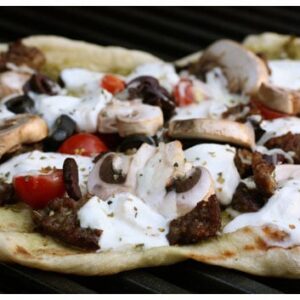 a pizza being cooked on a grill