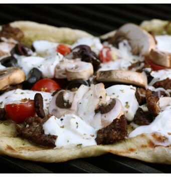 a pizza being cooked on a grill