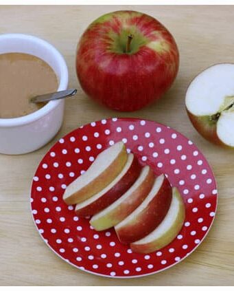 a plate of apple slices and a dish of caramel sauce
