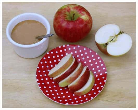 a plate of apple slices and a dish of caramel sauce