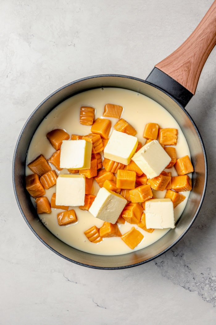 Overhead view of butter, caramels, and condensed milk in saucepan