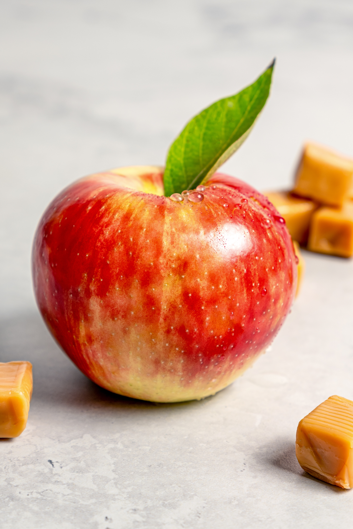 Apple with droplets of water and leaf