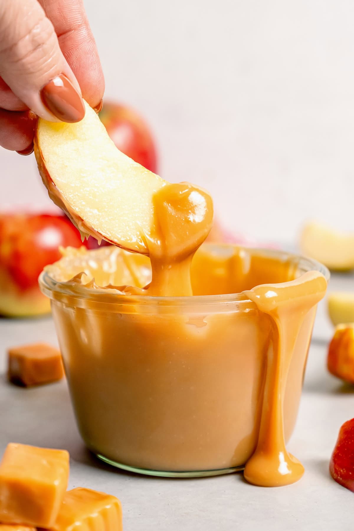 Dipping apple into jar of caramel apple dip