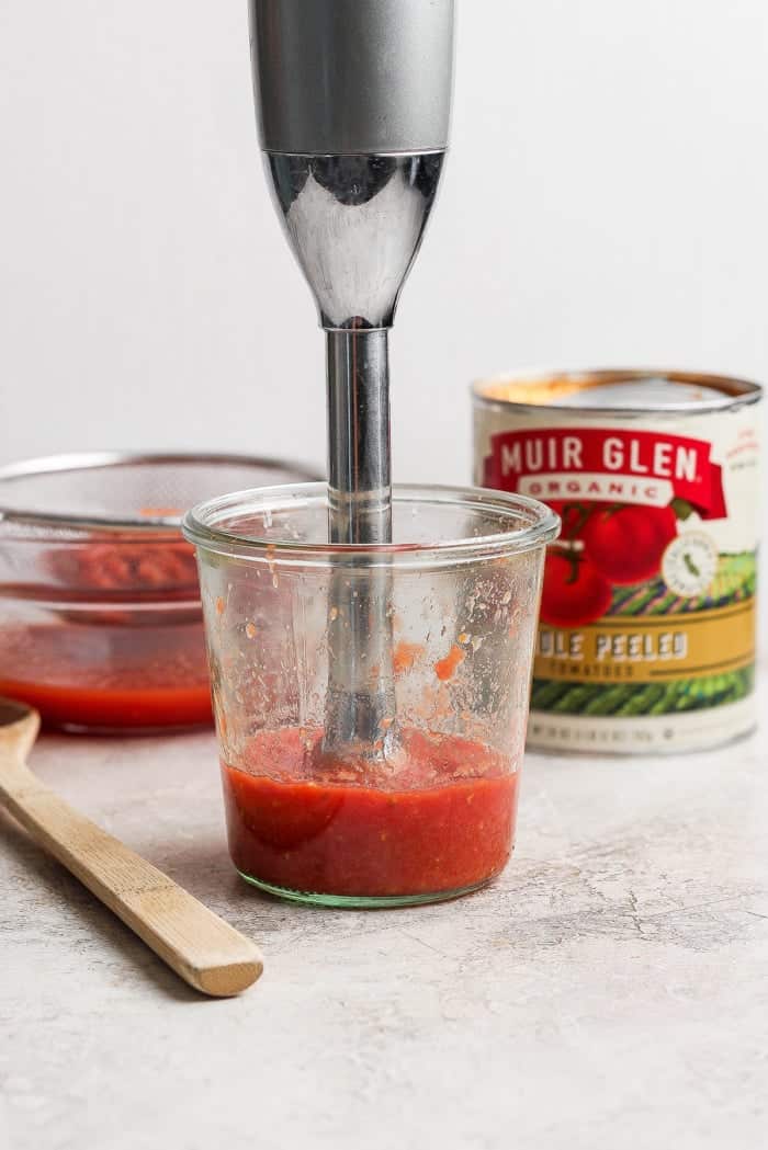 This Grilled Pizza recipe is tested and perfected, with a homemade dough that doesn't fall through the grates. Smoky, crispy, and delicious! Immersion blender pureeing pizza sauce in jar.