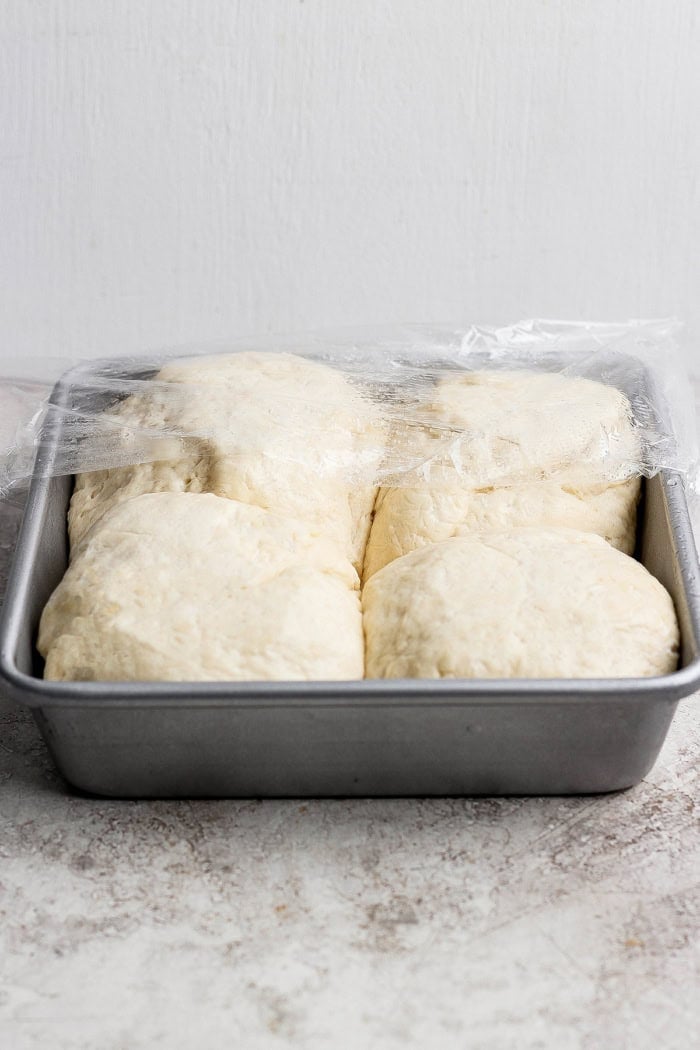 This Grilled Pizza recipe is tested and perfected, with a homemade dough that doesn't fall through the grates. Smoky, crispy, and delicious! Pizza dough in pan after rising.