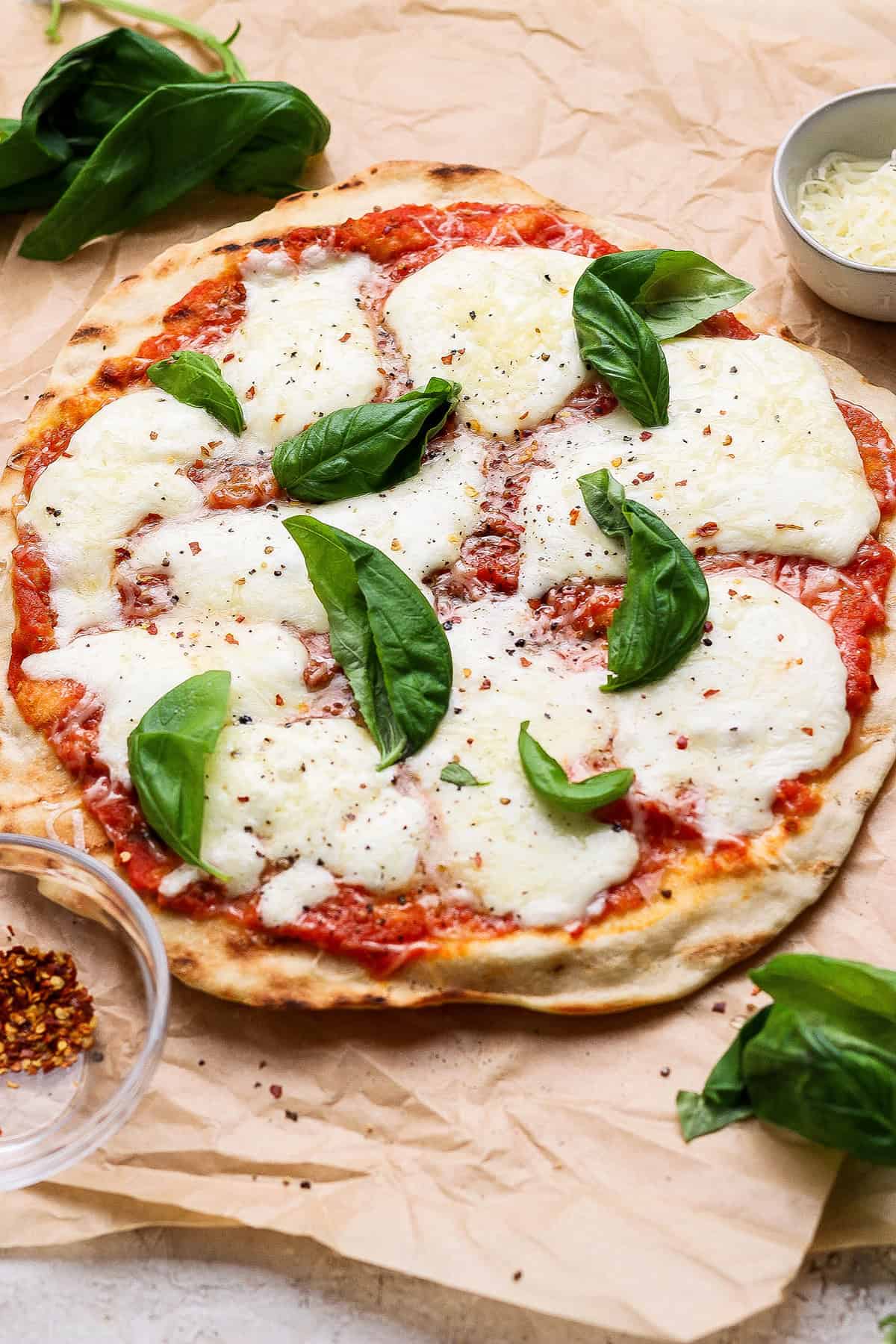 This Grilled Pizza recipe is tested and perfected, with a homemade dough that doesn't fall through the grates. Smoky, crispy, and delicious! Grilled pizza with fresh mozzarella and basil.