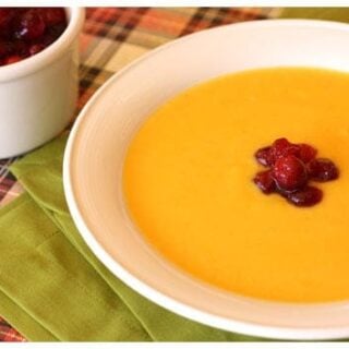 a bowl of squash soup with cranberries