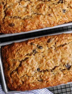 two loaves of apple bread in pans on cooling rack