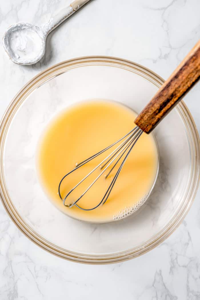 Apple cider and cornstarch slurry in bowl with whisk