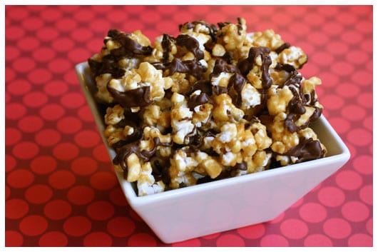 caramel corn with chocolate drizzle in a white dish 