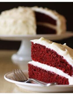 a slice of red velvet cake taken out of a whole cake