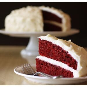 a slice of red velvet cake taken out of a whole cake