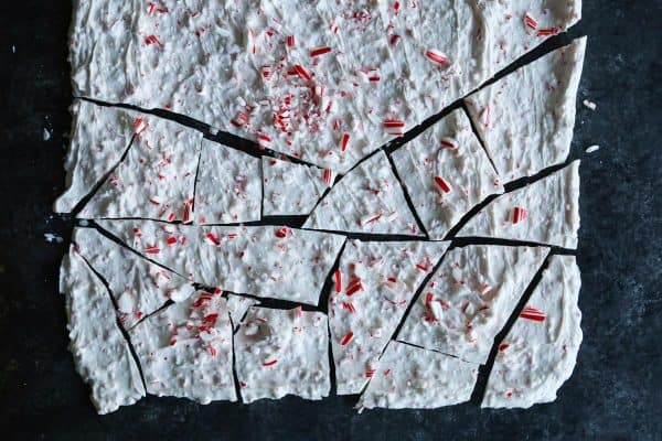Overhead view of a sheet of peppermint bark partially broken into pieces.