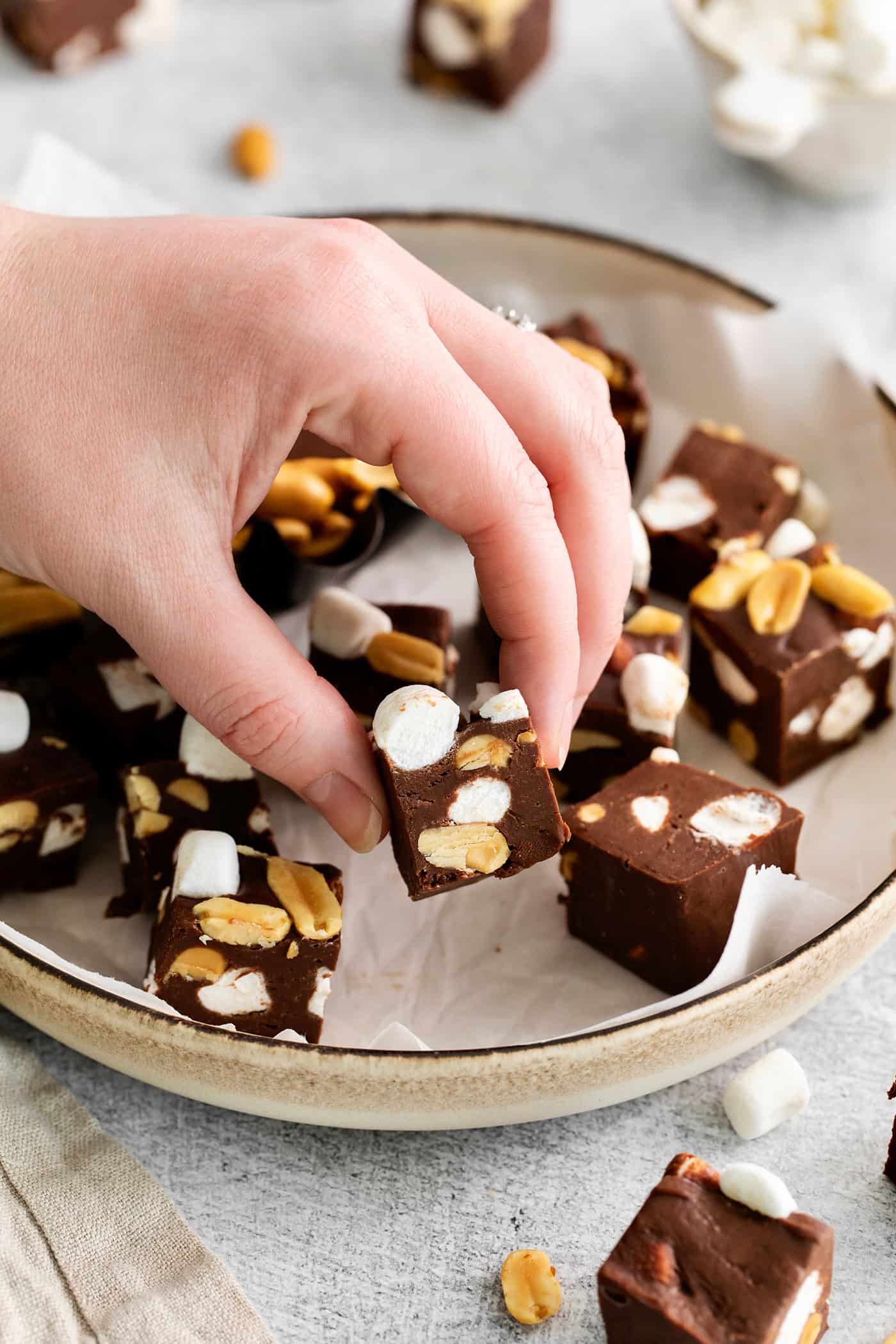 A hand grabbing a piece of rocky road fudge